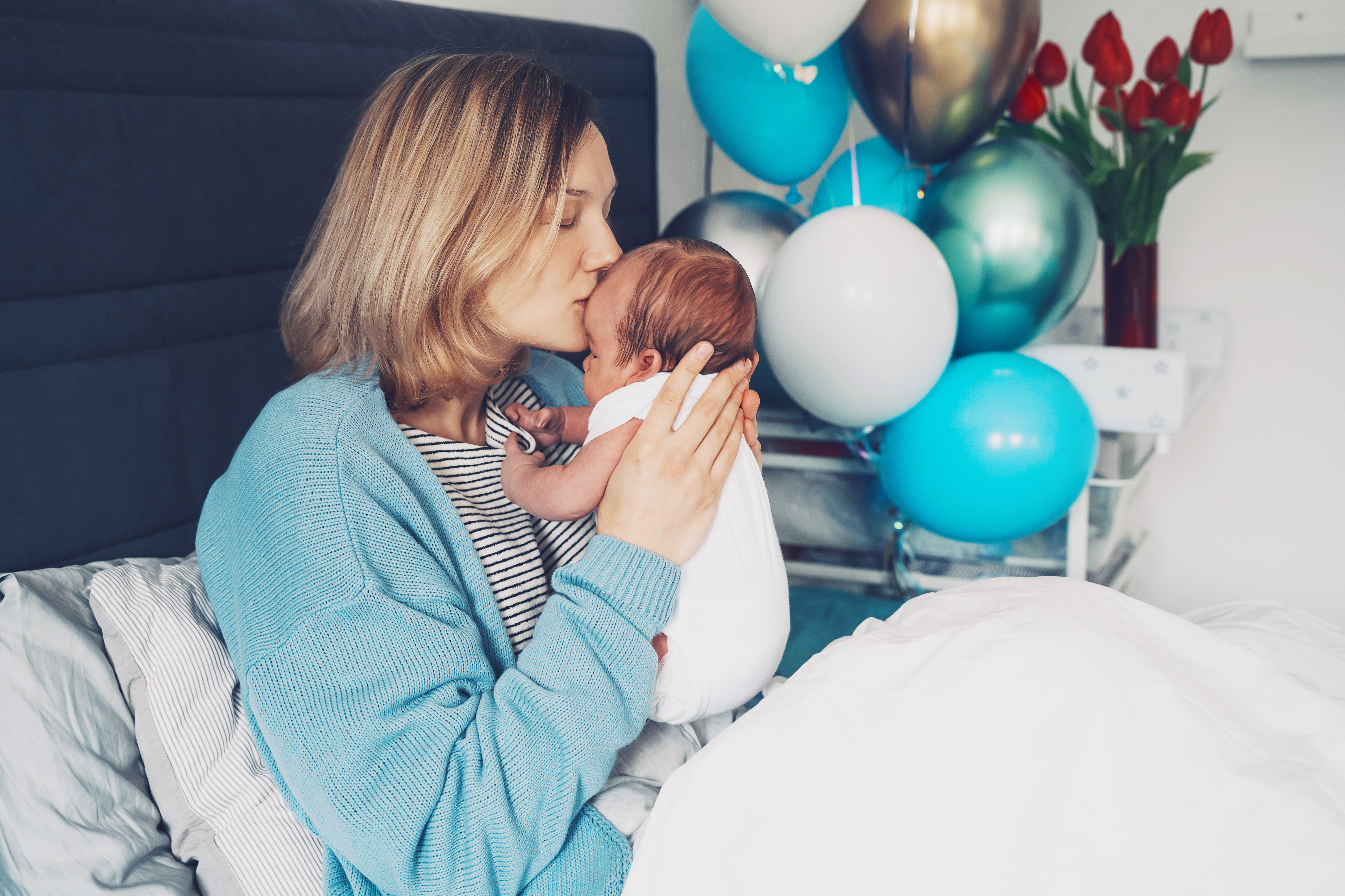 After baby delivery mother and baby at home. Mother holds her ne